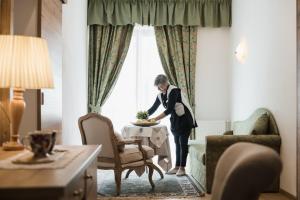 阿拉巴Laguscei Dolomites Mountain Hotel的站在酒店房间桌子上的女人