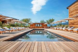 克罗泽特Jiva Hill Resort - Genève的木制甲板上配有椅子和遮阳伞的游泳池