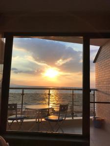 帕莫瑞Elizabeth' Luxury Apartments的阳台享有日落美景,配有桌椅。