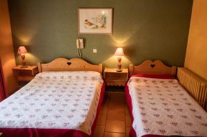 圣马丹韦叙比耶Hotel Relais Saint Louis的配有两盏灯的小房间内的两张床