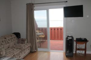 博纳维斯塔Robbins by the Sea的带沙发和滑动玻璃门的客厅