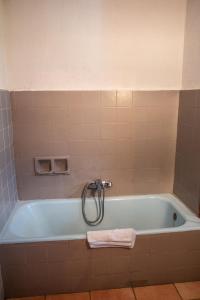 圣马丹韦叙比耶Hotel Relais Saint Louis的带浴缸的浴室和毛巾