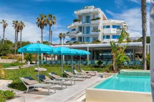 拉古萨码头Acacia Palace的游泳池旁的酒店拥有椅子和遮阳伞