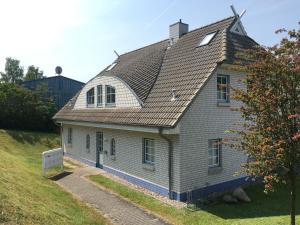 塞多夫Sellin Ferienwohnung Maritim的山坡上一座带灰色屋顶的老房子