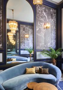 波尔多快乐文化柯迪酒店的一间设有三张蓝色的床和一张蓝色沙发的房间
