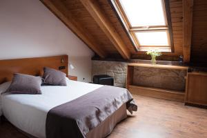 RosalCasa Rural Abadia Eiras的一间卧室设有一张大床和一个窗户。