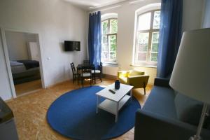 施特拉尔松德Nr9Marinehafen - Ferienwohnungen的带沙发和蓝色地毯的客厅