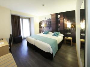 巴利亚多利德艾勒恩纳拉精品酒店的酒店客房配有一张带蓝色枕头的大床