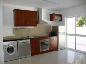 卢斯Belinha Guest House的厨房配有洗衣机、水槽和洗碗机。