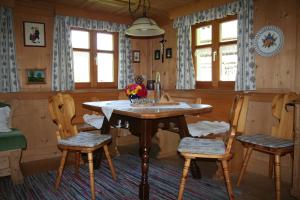 圣加伦基希Ferienhaus Schnetzer的一间带桌子和两把椅子的用餐室