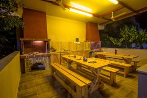 伊拉克里萨Rent House Karavi的餐厅设有木桌和比萨饼烤箱