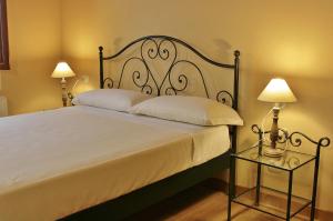 洛迪卡维瑞格农庄酒店的一间卧室配有一张大床和两盏灯