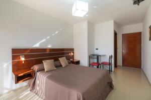 上格拉西亚丽兹酒店的一间卧室配有一张大床和木制床头板