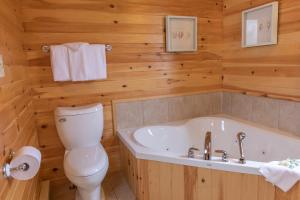 卡文迪西菲尔维小木屋的浴室配有白色卫生间和浴缸。