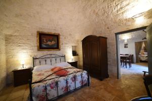 马丁纳弗兰卡Trullo Barratta的卧室配有一张石墙床