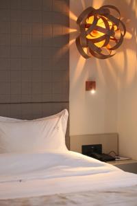 卡尼奥提Athinais Luxury Apartments的一张带白色枕头和吊灯的床