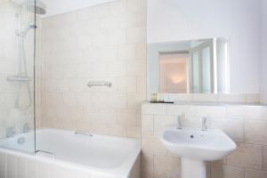 惠茨特布尔欧陆酒店的浴室配有盥洗盆、浴缸和盥洗盆