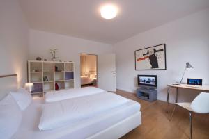 柏林Art'Appart Suiten - kontaktloser Check-In的白色卧室配有白色的床和书桌