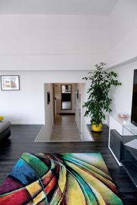萨格勒布Main Square Oval Apartment的一间客厅,地板上铺着色彩缤纷的地毯