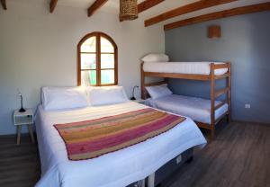 圣佩德罗·德·阿塔卡马Hotel Jardin Atacama的一间卧室设有两张双层床和一扇窗户。