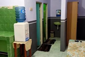 布罗莫Holiday Home Anggun Bromo的浴室在热水器顶部设有蓝色桶