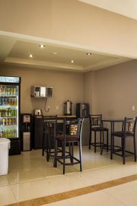 坦皮科BONITTO INN® Tampico Lomas的厨房配有桌椅和冰箱。