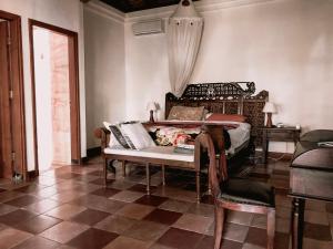 金巴兰Bale Asri Bukit Jimbaran的卧室配有1张床、1张桌子和1把椅子
