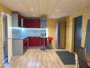 ValtinaVäike-Puusmetsa puhkemaja的一间厨房,配有红色橱柜和红色凳子