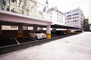 天安市Cheonan K Hotel的停在大楼旁边的停车场的汽车