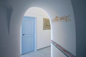 易莫洛林Katerina's Castle - Caldera Cave Hotel的通往白色走廊的拱门,设有蓝色的门