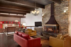 斯波坎斯波坎机场华美达酒店的客厅设有壁炉和红色椅子
