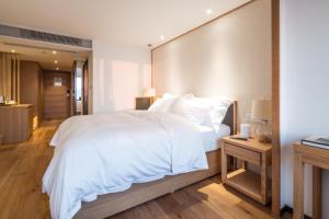 重庆重庆白云亲舍精品酒店的卧室配有一张白色大床和木制床头板