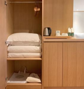 重庆重庆白云亲舍精品酒店的房间里的一个橱柜,上面有一堆毛巾