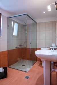 阿斯特里昂Aromatokipos House的一间带玻璃淋浴和水槽的浴室