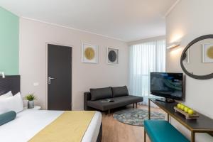 恩波其克莱昂纳多死海俱乐部酒店 - 全包式的一间卧室配有一张床、一台电视和一张沙发