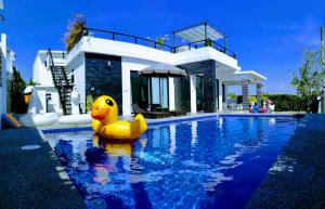 华欣@钱恩泳池别墅的一座房子前的游泳池里的黄橡皮鸭
