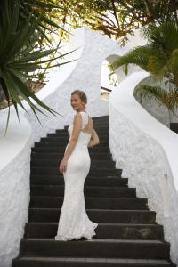 特鲁欧克比赫斯木麻黄度假酒店的站在楼梯上的穿着白色衣服的女人