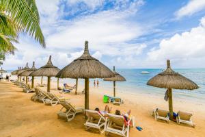 特鲁欧克比赫斯木麻黄度假酒店的海滩上的一组沙滩椅和遮阳伞