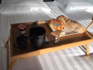 旺德尔港Les cabanons de Mémé Jeannette的床上的托盘,上面有食物和面包