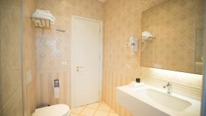 地拉那Royal Hill Hotel的一间带水槽、卫生间和镜子的浴室