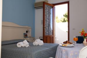 圣维托罗卡波Camping Village La Pineta的一间卧室配有两张床和一张带一盘食物的桌子。