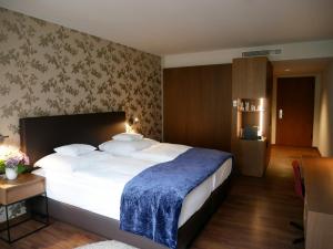 维尔茨堡雷布斯托克贝斯特韦斯特高级酒店的一间卧室配有一张带蓝色毯子的大床