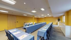 佛里茨斯坦德客栈餐厅酒店的一间设有蓝色桌椅的教室,墙壁为黄色