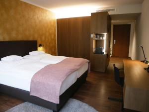 维尔茨堡雷布斯托克贝斯特韦斯特高级酒店的酒店客房设有一张大床和一张书桌。