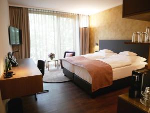 维尔茨堡雷布斯托克贝斯特韦斯特高级酒店的配有一张床和一张书桌的酒店客房