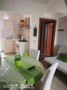 比萨Villa Galilei Rooms的厨房以及带绿色桌椅的用餐室。