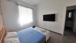 雅典KYMA Apartments - Athens Acropolis 2的一间卧室配有一张床和一台平面电视