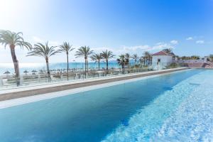 帕尔马海滩弗拉明戈麦森豪斯超四星级酒店 - 仅限成人入住的一座棕榈树和海洋的大型游泳池