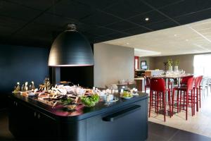 布雷斯特布雷斯特钟楼酒店 - 古埃斯努机场酒店的一间餐厅,配有餐桌和食物