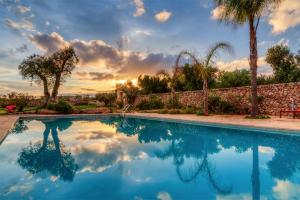 曼杜里亚Masseria Sorani的一座游泳池,位于一个享有日落美景的庭院内